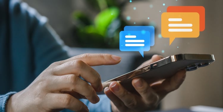 Hand holding a smart phone with 4 text message bubbles