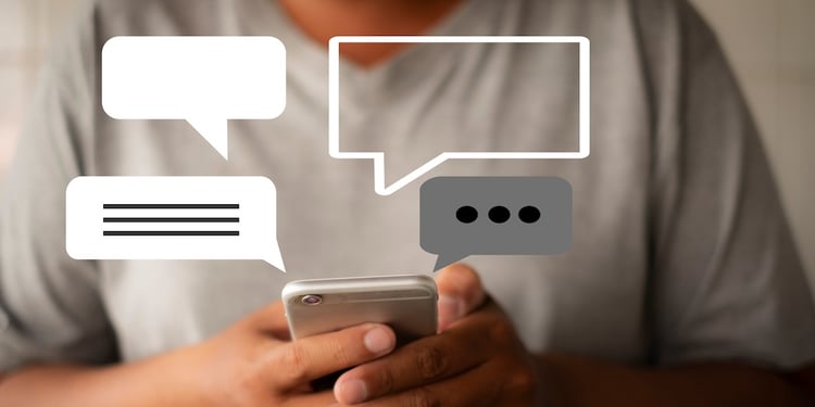 Man holding a smartphone with 4 graphic text bubbles 